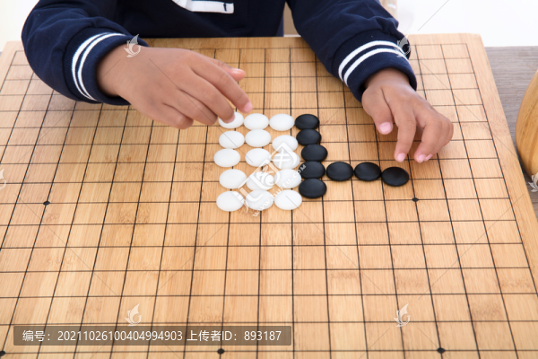 小孩子在棋盤上學(xué)習(xí)下圍棋