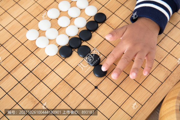 小孩子在棋盤上學(xué)習(xí)下圍棋