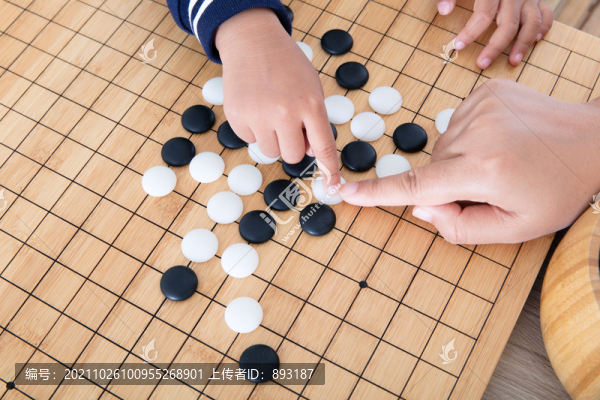 小孩子的手在擺放圍棋棋子