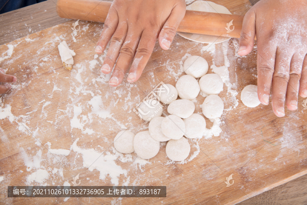 拍攝一雙手在砧板上搟餃子皮