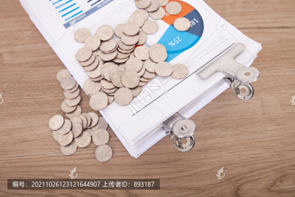商業(yè)資料上一堆散落的美元硬幣