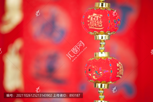 紅色春聯(lián)前掛著一串燈籠飾品