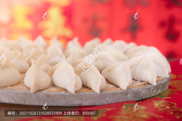 紅色的背景前包好待煮的節(jié)日餃子