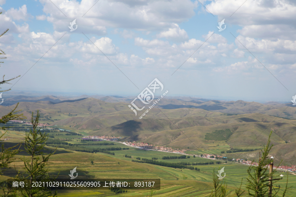 山頂遠(yuǎn)望藍(lán)天白云下的草原風(fēng)光