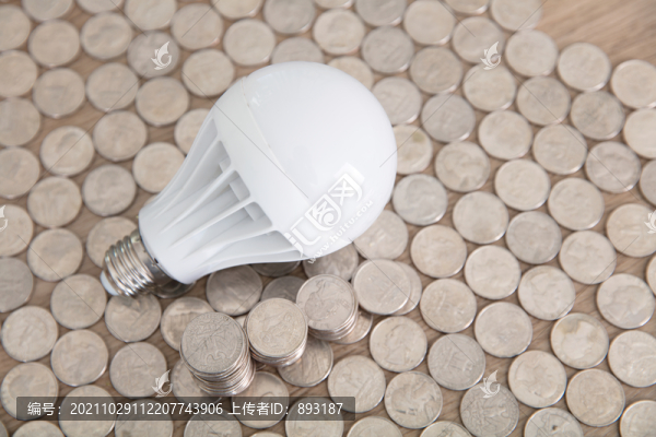 美元硬幣鋪成的背景上一個(gè)燈泡
