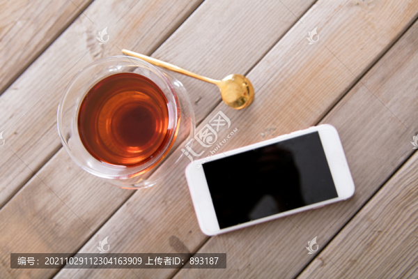 桌子上一杯紅茶和一部手機