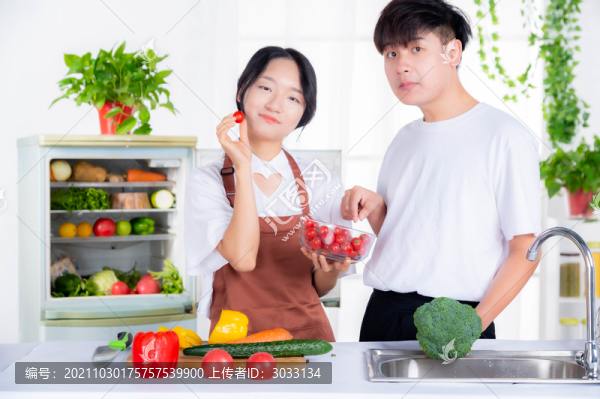 情侶從冰箱里拿蔬菜準(zhǔn)備做飯