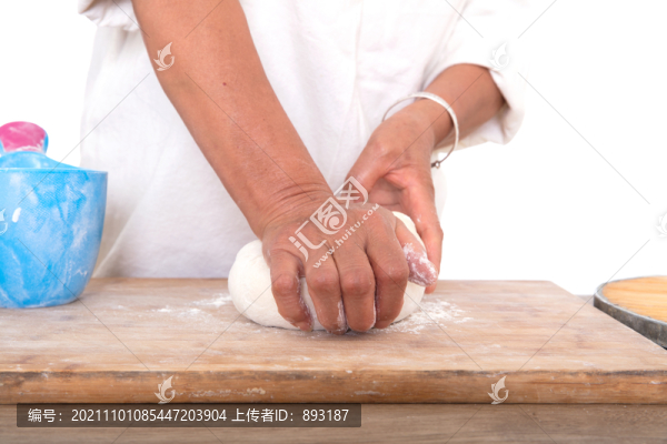 面點師在使勁揉搓砧板上的面團