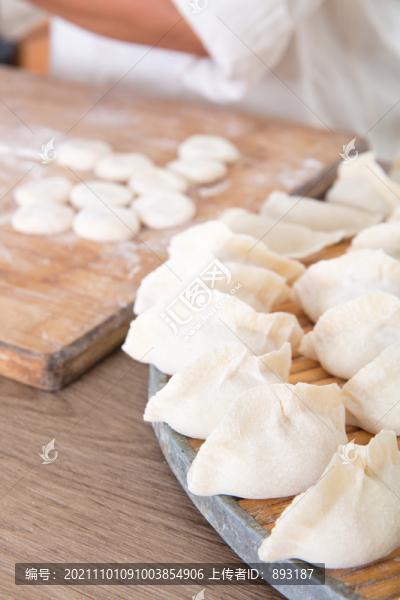 餃子及背景里忙碌制作的場(chǎng)景
