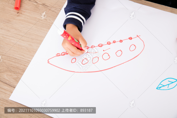 俯視拍攝孩子在白紙上畫簡(jiǎn)筆畫
