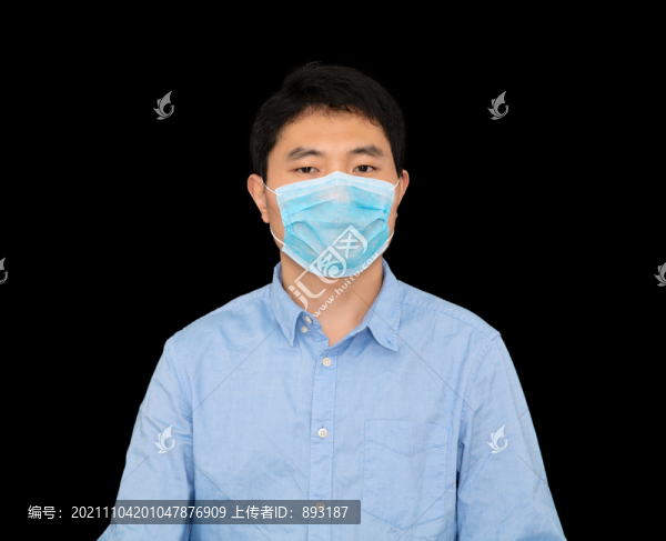 戴著口罩站在黑背景前的男士