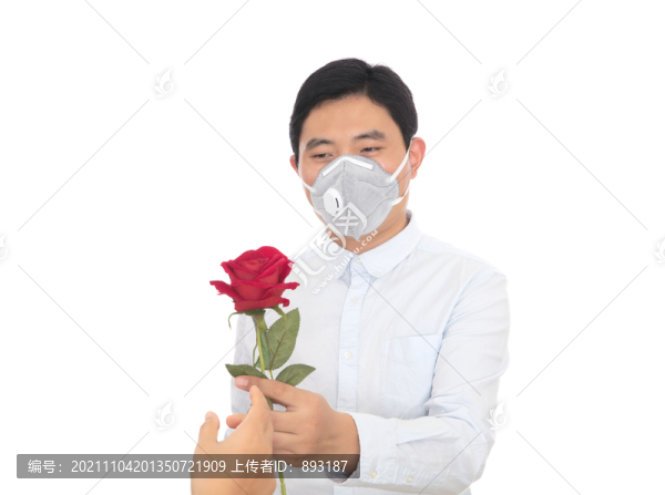 男士拿下口罩聞紅玫瑰在白背景前