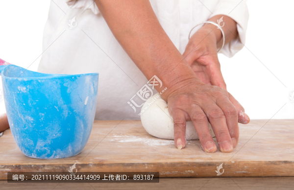 面點(diǎn)師在白背景前的桌子上揉面