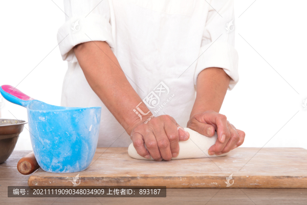 面點(diǎn)師在白背景前的桌子上揉面