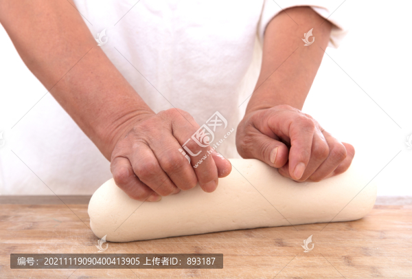 面點(diǎn)師在白背景前的桌子上揉面