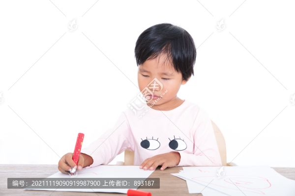 可愛的中國小女孩在認(rèn)真的畫畫