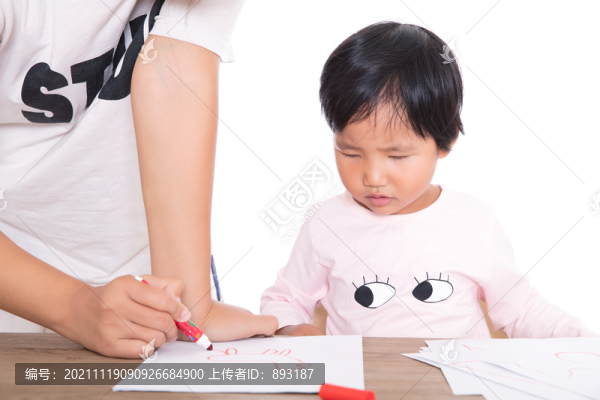 老師在認(rèn)真的輔導(dǎo)小女孩畫(huà)畫(huà)