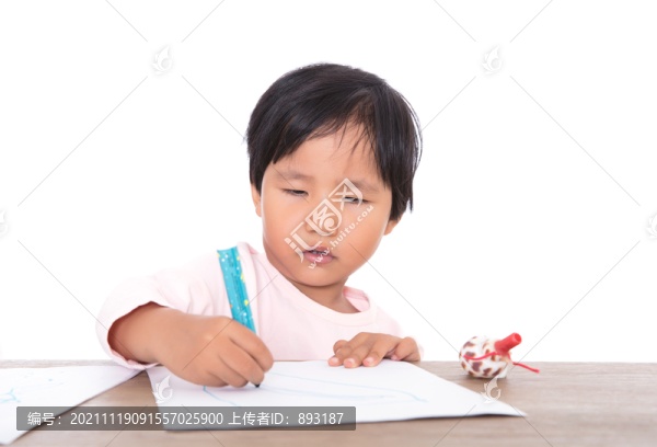 趴在桌子上認(rèn)真畫畫的小女孩