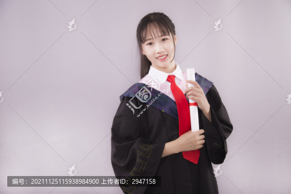 純色背景下穿著學(xué)士服的女孩