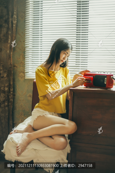 窗戶邊坐著的穿著黃色短袖的女孩