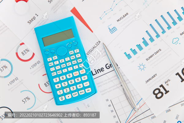 計(jì)算器和簽字筆在文件資料上