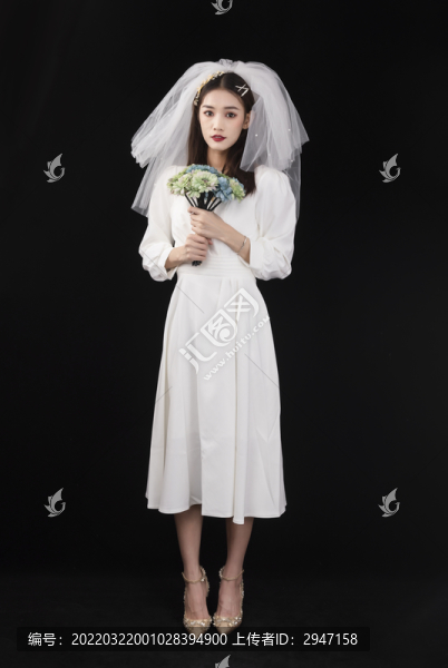 穿著白色連衣裙戴著頭紗的女性