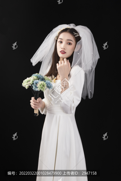 穿著白色連衣裙戴著頭紗的女性