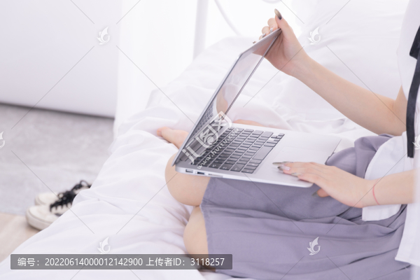 女孩在床上使用筆記本電腦