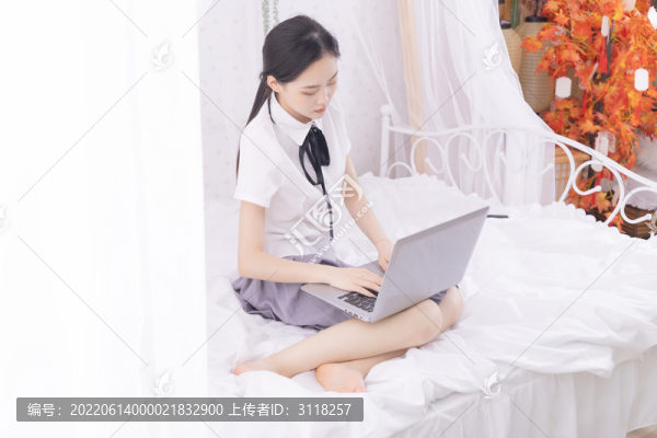 女孩在床上使用筆記本電腦