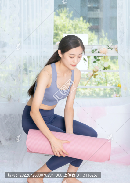 室內(nèi)女性整理瑜伽墊