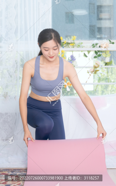 室內(nèi)女性整理瑜伽墊