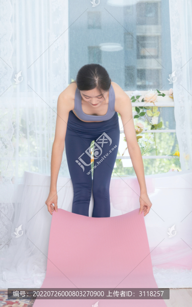 室內(nèi)女性整理瑜伽墊