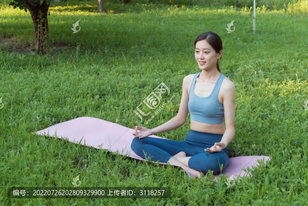 草地上做瑜伽動(dòng)作的女性