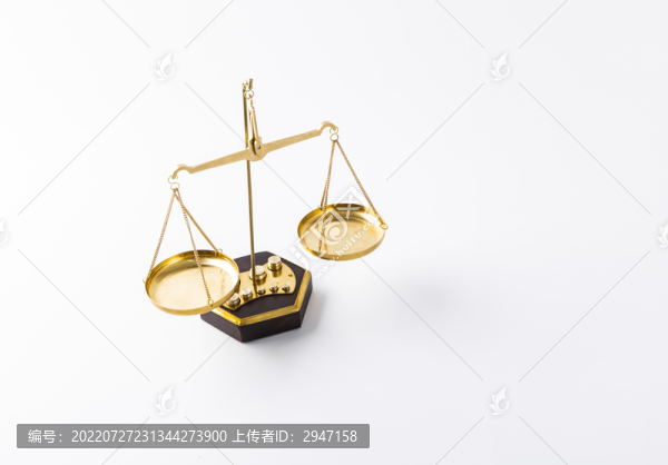 白色背景下放著的金色天平