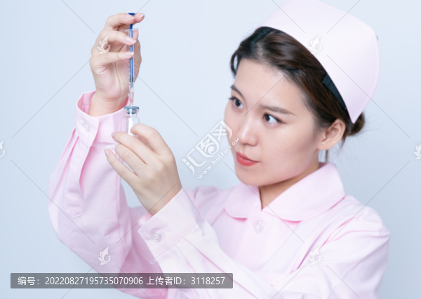 年輕女醫(yī)護(hù)人員手持注射器