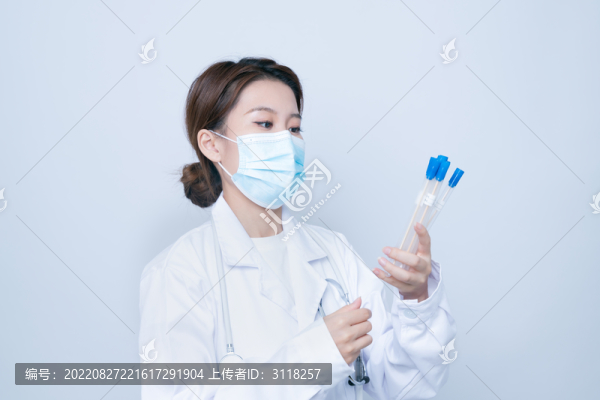 手持檢測樣本的年輕女醫(yī)生