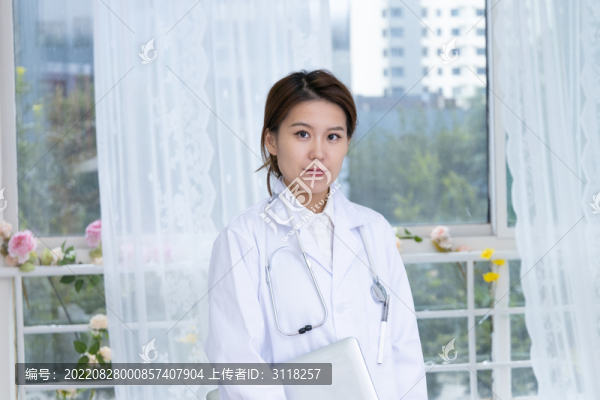室內女醫(yī)生手持筆記本電腦