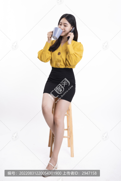 穿著黃色正裝拿著水杯的女性