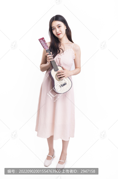 穿著連衣裙拿著尤克里里的女人