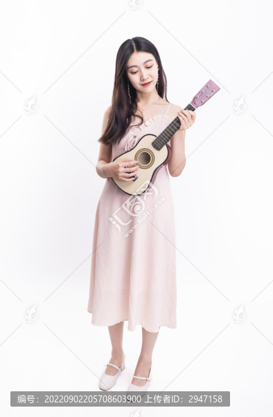 穿著連衣裙拿著尤克里里的女人