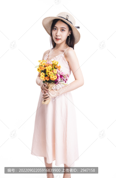 穿粉色連衣裙拿著一束花的女人