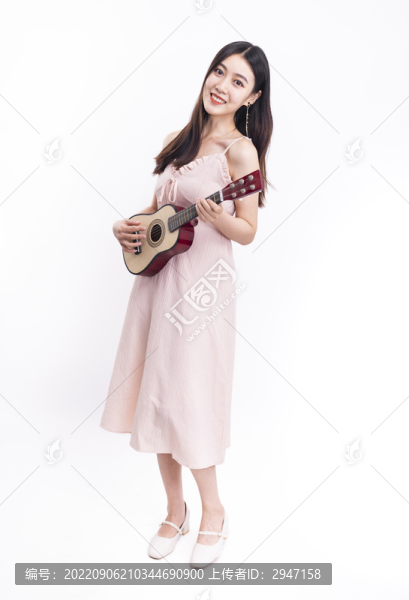 穿著連衣裙拿著尤克里里的女人