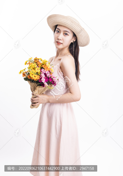 穿粉色連衣裙拿著一束花的女人