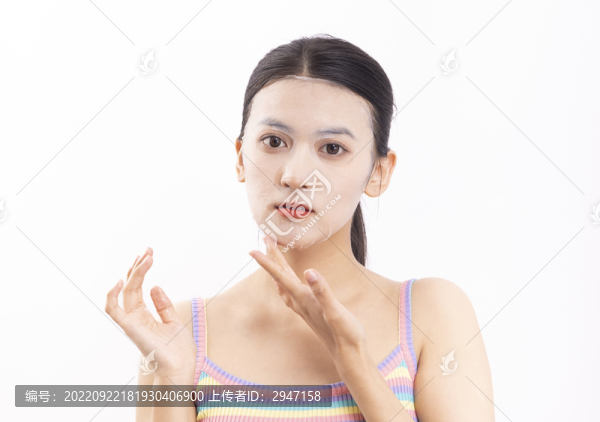白色背景下敷面膜的年輕女人