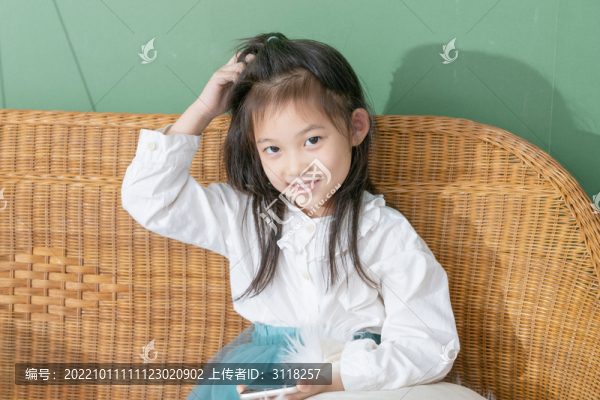 躺椅上玩手機(jī)的小女孩