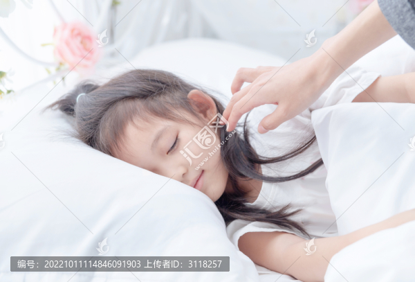 手撫摸床上熟睡的小女孩