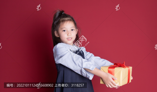 小女孩學(xué)生裝扮拿著禮物盒