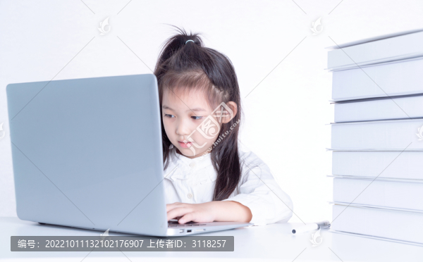 書桌上使用電腦學(xué)習(xí)的小女孩