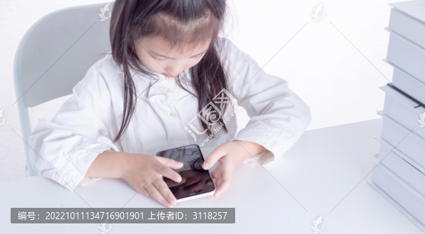 書桌上使用手機的女孩俯視