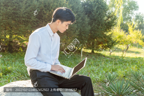手持筆記本電腦的男青年